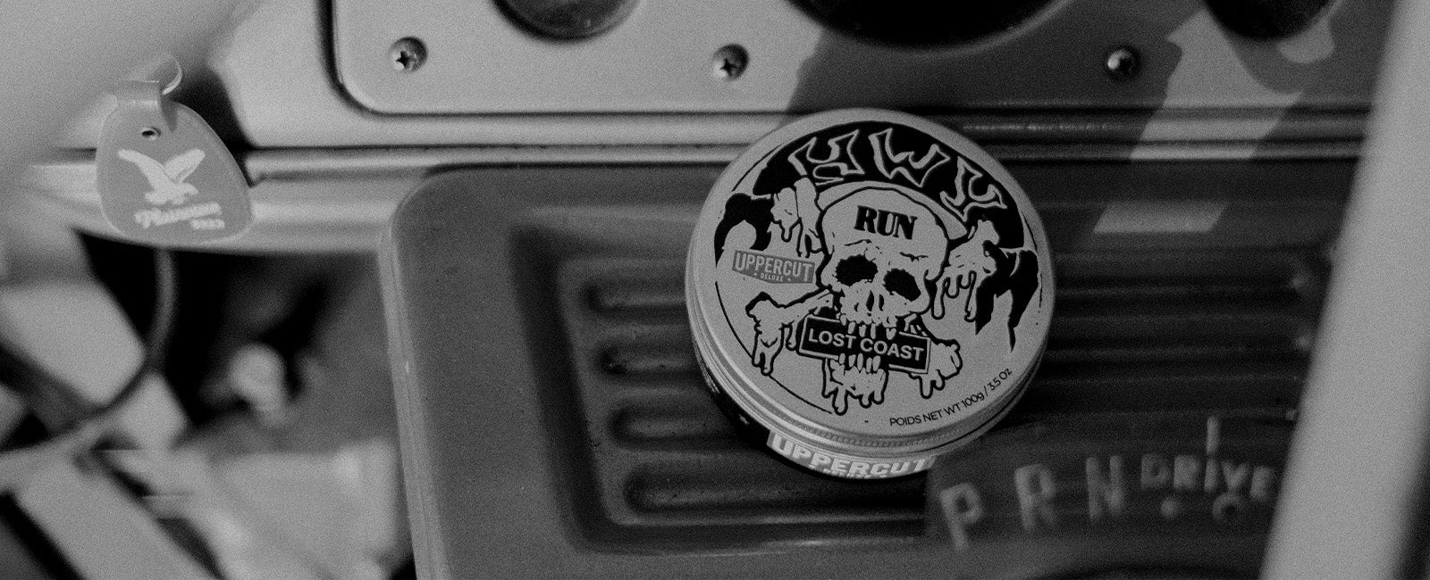 HWY x Uppercut Deluxe Tin sitting on Dashboard of Car