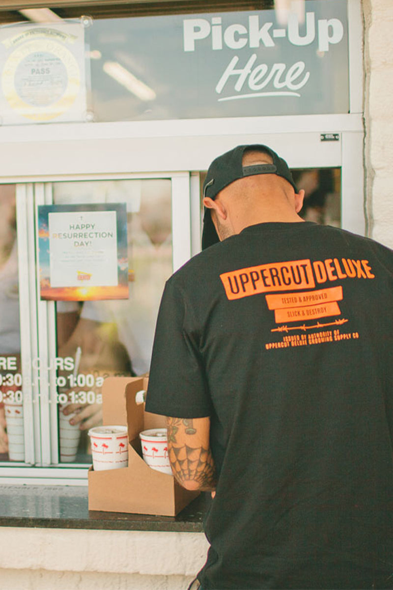 Man ordering food wearing uppercut deluxe headliner shirt and hat