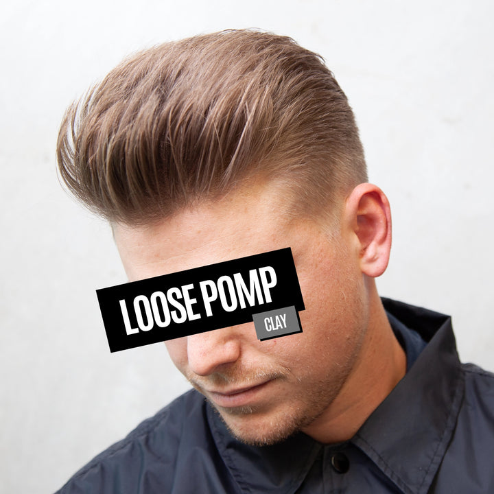 A man wearing a stylish pompadour hairstyle with light brown hair and a faded side cut, wearing a dark navy button-up shirt. A black text overlay reads 'LOOSE POMP' with a small 'CLAY' label on the side, set against a plain light gray background.